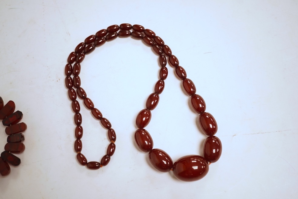 A single strand graduated oval simulated amber bead necklace, 72cm, gross weight 64 grams, together with a simulated cherry amber bracelet.